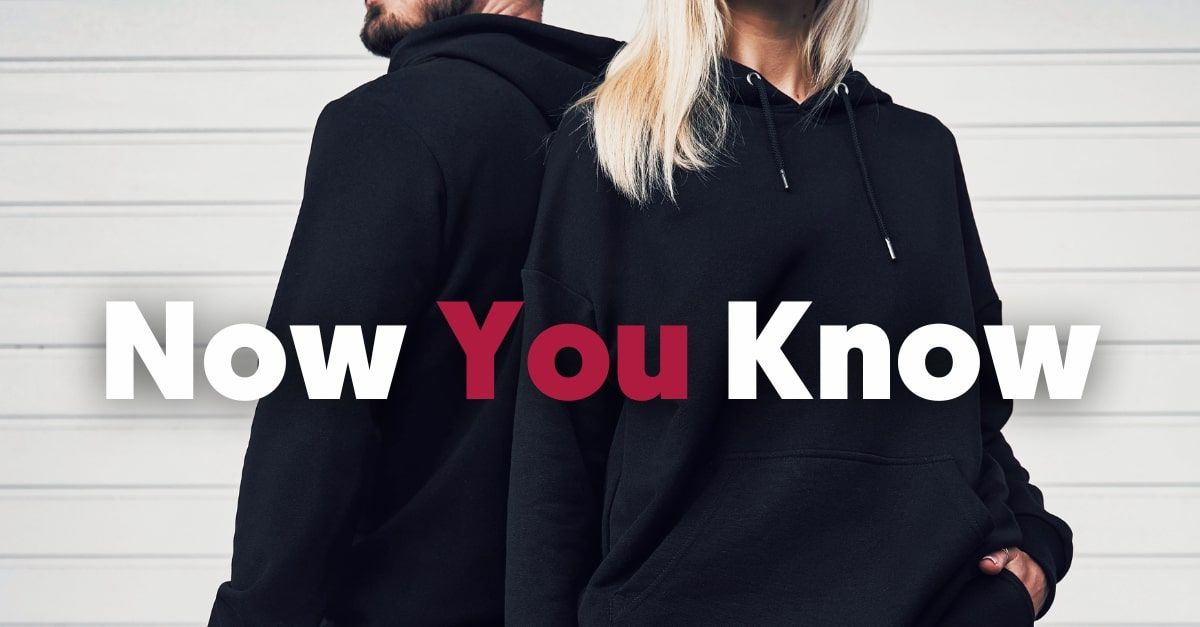 A man and a woman are dressed in similar black hoodies